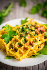 Egg omelet stuffed with greens and sausage fried in the form of waffles
