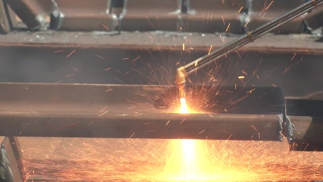 Close-up of the hand of an industrial worker working on the process of cutting rails. A male worker cuts steel using a plasma cutter. Rail Cutting With Welding Torch