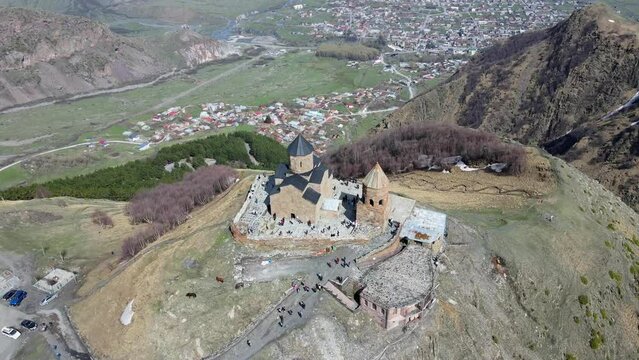 Camera drone flies around Holy Trinity Church (Gergeti Trinity Church) near the village of Stepantsminda in Georgia