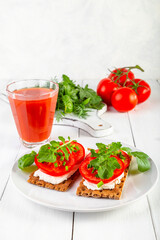 Crispbread with curd cheese, tomatoes, green onions, arugula and basilica. Delicious and healthy breakfast