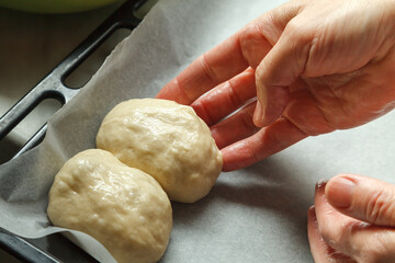 Confectioner forms buns with cherries from baking dough
