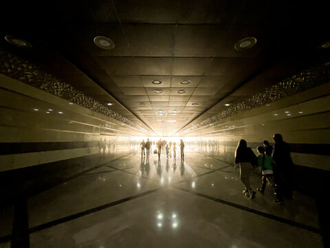 Modern subway station tunnel interior with people walking