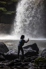 Fototapeta premium People are in the forest watching waterfalls and watching the beautiful nature playing in the water and relaxing on vacation. At Khao Yai National Park, Thailand, 16-05-2022