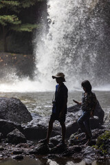 Obraz premium People are in the forest watching waterfalls and watching the beautiful nature playing in the water and relaxing on vacation. At Khao Yai National Park, Thailand, 16-05-2022