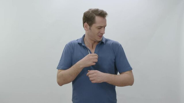 Man who is sweating heavily isolated on white background smells bad.Young man worried and showing sweating spot problem with sweating, sniffing armpit.Bad odor, excessive sweating concept.