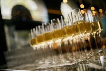 many glasses are on the bar. A lot of wine glasses with a cool delicious champagne or white wine at...