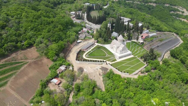 A camera drone flies forward and descends towards the Monastery of St. Nino at Bodbe, Georgia