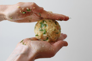 Hands making Semmelknödel. Preparing austrian traditional dumplings with parsley.