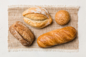 Assortment of freshly baked bread with napkin on rustic table top view. Healthy unleavened bread. French bread