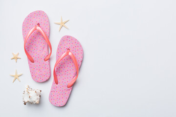 Flat lay composition with flip flops and seashell on colored background. Space for text top view