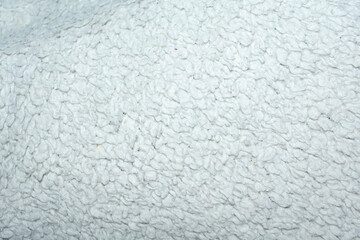 White fleecy  fur texture top view. Abstract wallpaper, textile surface. Fashion trends feminine...