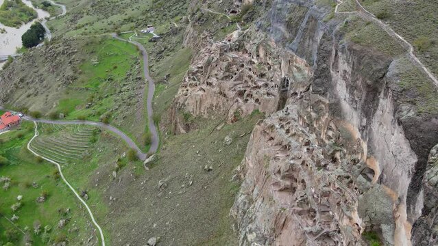 A camera drone flies above and along Vardzia cave city and monastery, Georgia