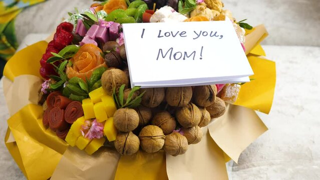 sweet bouquet gift and card with the inscription I love you mom.Mother's day holiday concept.son expresses love for mom.letter of gratitude to mom