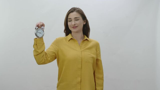Character portrait of young woman holding a small desk clock. The woman shows that time has passed and it is necessary to use time well. Young woman draws attention to aging.
