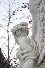 White marble sculpture against the sky and rowan branches with red berries