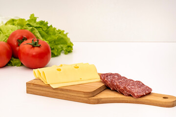 Smoked sausage with slices isolated on white background. Smoked sausage on wooden cutting board or plate, delicious snack.