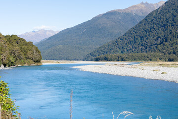 Scenic Makarora River flowing between bush-clad mountains of Southern Alps