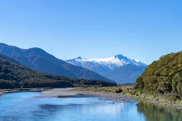Photo sur Plexiglas Aoraki/Mount Cook Makarora River flows over wider river bed between bush-clad South Alps mountains.