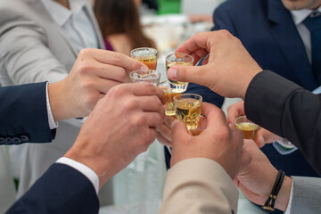 Friends celebrate with rakia brandy at a Serbian wedding