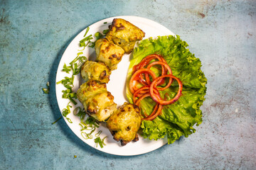 Chicken Green Hariyali tikka boti platter with lime and salad in a dish top view of indian barbeque...