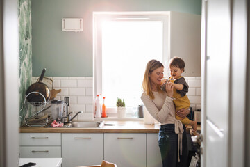 Young mother with child in the kitchen 
