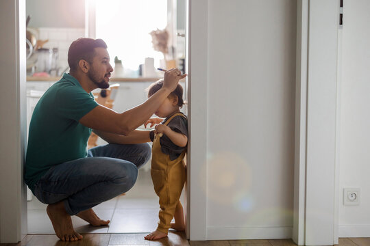 Father with his young child in the home kitchen 
