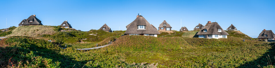 Fototapeta na wymiar Traditional thatched roof houses in summer, Hörnum, Sylt, Schleswig-Holstein, Germany
