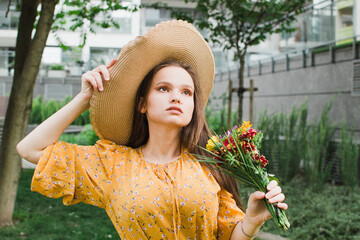 woman in a straw hat with a bouquet