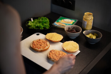 Close-up view of vegan burger buns while cooking process on kitchen table.