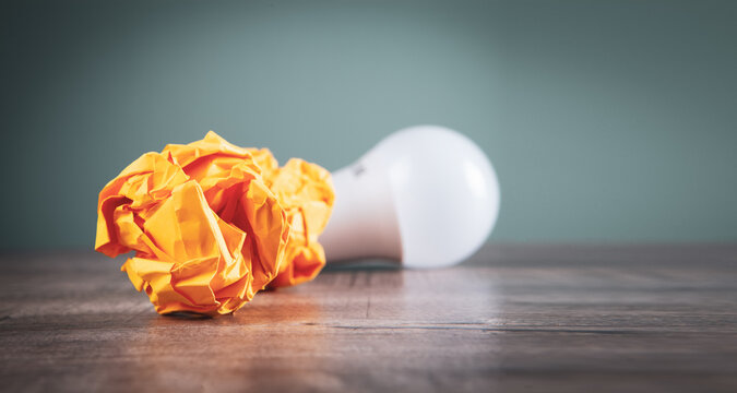 crumpled papers and a light bulb on the table