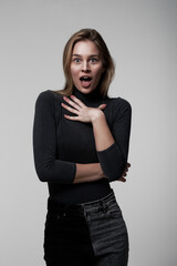 A young and beautiful brunette posing on a white background, shocked