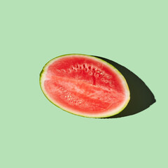 Cut watermelon on green pastel background