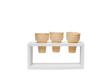 empty waffle cones in wood holder white background