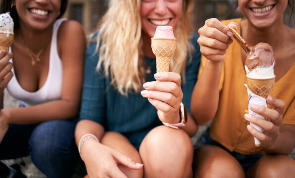 Three young woman eating ice cream cones close up