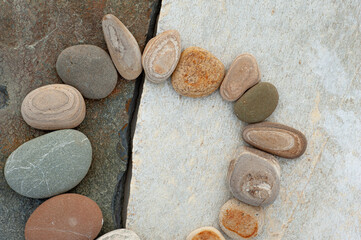 Beach stone circle on rock slab. 