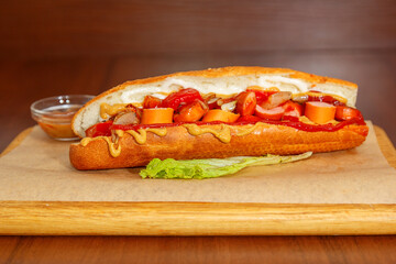 Sandwich with cutlet lies on a pacifier covered with kraft paper, and the side of the sauce to it
