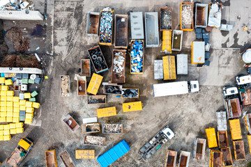Top view of a landfill with various waste. Many dumpsters and garbage trucks sorting and recycling garbage in the industrial areas of the city
