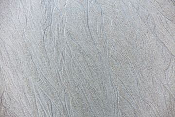 Sand background and texture. Wet beach sand texture after low tide. Sand with wave print. Ripple on the beach sand. 