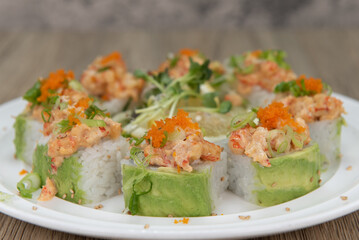 Asian cuisine sushi roll with lobster and shrimp tempura topped with green onion and masago for a very hearty meal