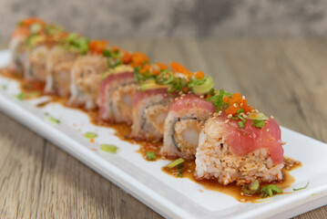 Asian cuisine sushi roll with krab meat mixed with shrimp tempura and topped with tuna, salmon, and white fish for a very hearty meal © motionshooter