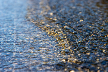 Water flooding over asphalt road close up