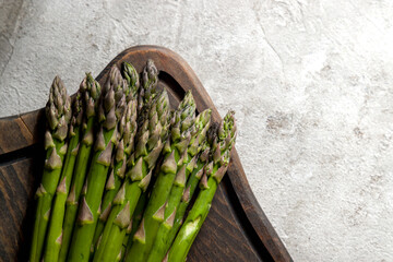a bunch of fresh asparagus on grey table top view with copy space