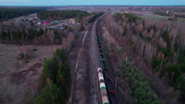 A freight trains travel towards the village.