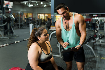 Fitness coach giving a diet plan to a fat woman