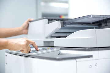 Copier printer, Close up hand office man press copy button on panel to using the photocopier or photocopy machine for scanning document printing a sheet paper and xerox photocopy. - obrazy, fototapety, plakaty