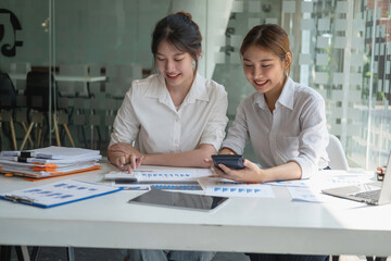 Marketing, Financial, Accounting, Planning, Team of business women analyze company results and profits with graph statistics. Use a laptop computer and a calculator to calculate the company's balance.