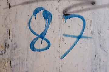 blue number 87 graffiti on the wall