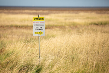 Danger, explosives sign in yellow grass at military firing range in Norfolk, UK