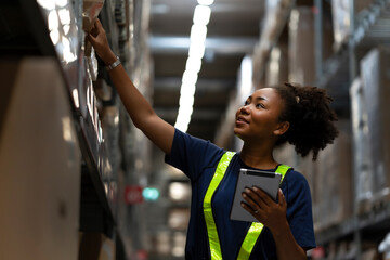 African American worker checking the stock on shelf in warehouse comparing the balancing number in system after delivery shipment. Using tablet to update online stock available for selling on website