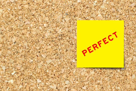 Yellow note paper with word perfect on cork board background with copy space